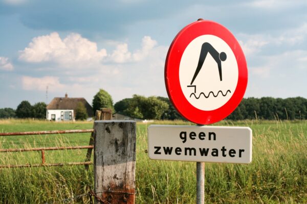 Foto van een verbodsbord met de tekst: geen zwemwater